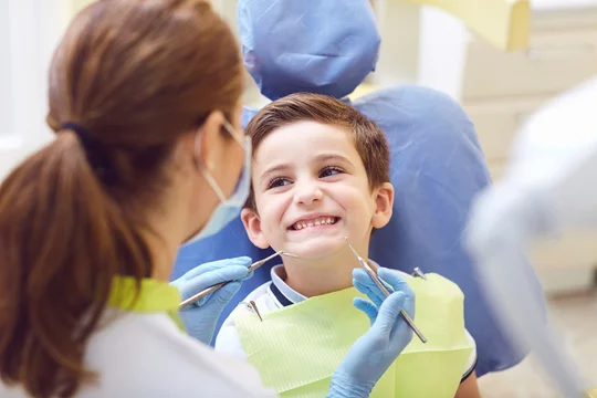 young child smiling brightly during a routine visit at a pediatric dental office near you